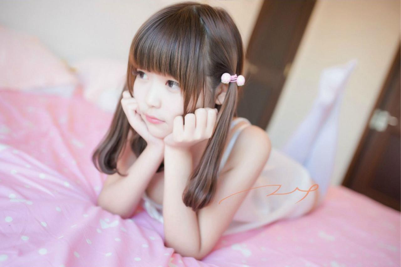 年糕颗颗颗双手撑着下巴扒在床上 侧脸