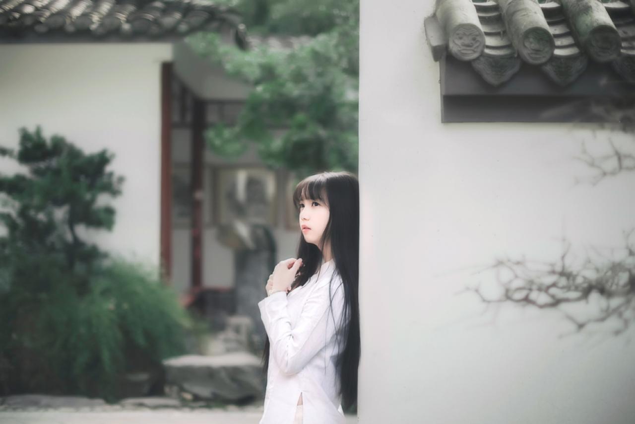 七七侧身靠在墙上