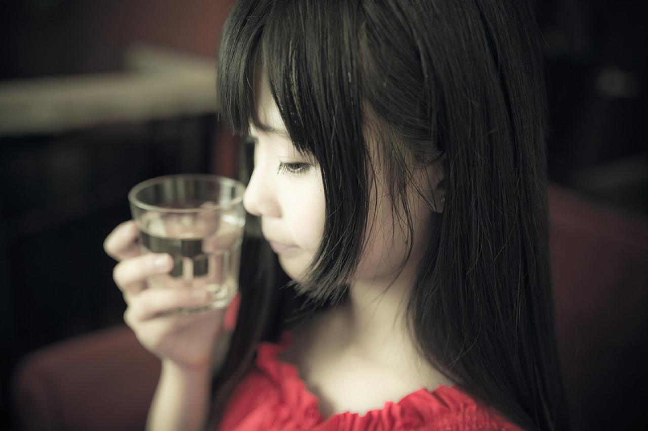 咖啡馆的萌妹子右手端起一杯水