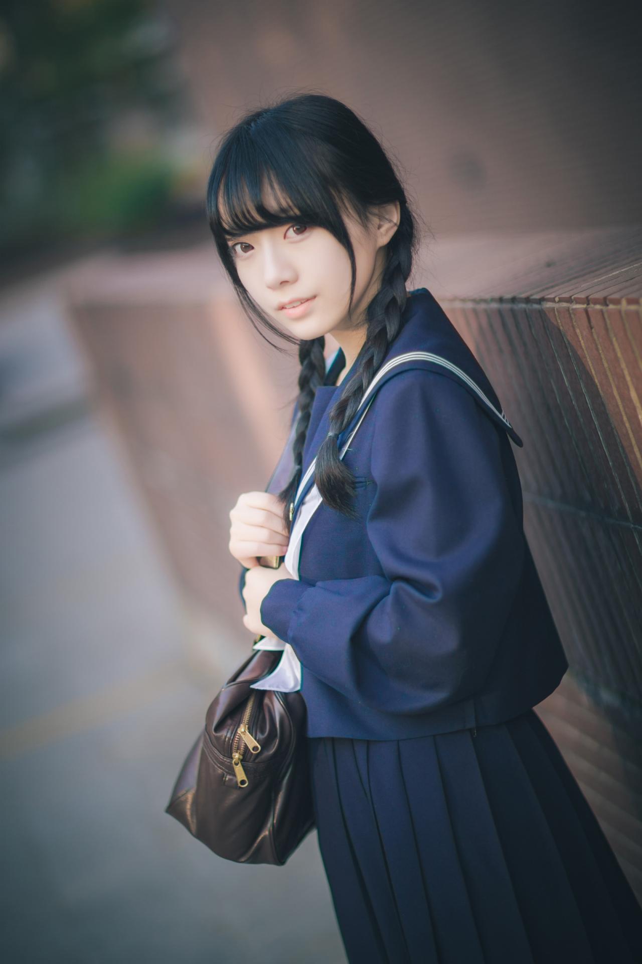 红提子挎着包站在红墙旁 侧面 立幅