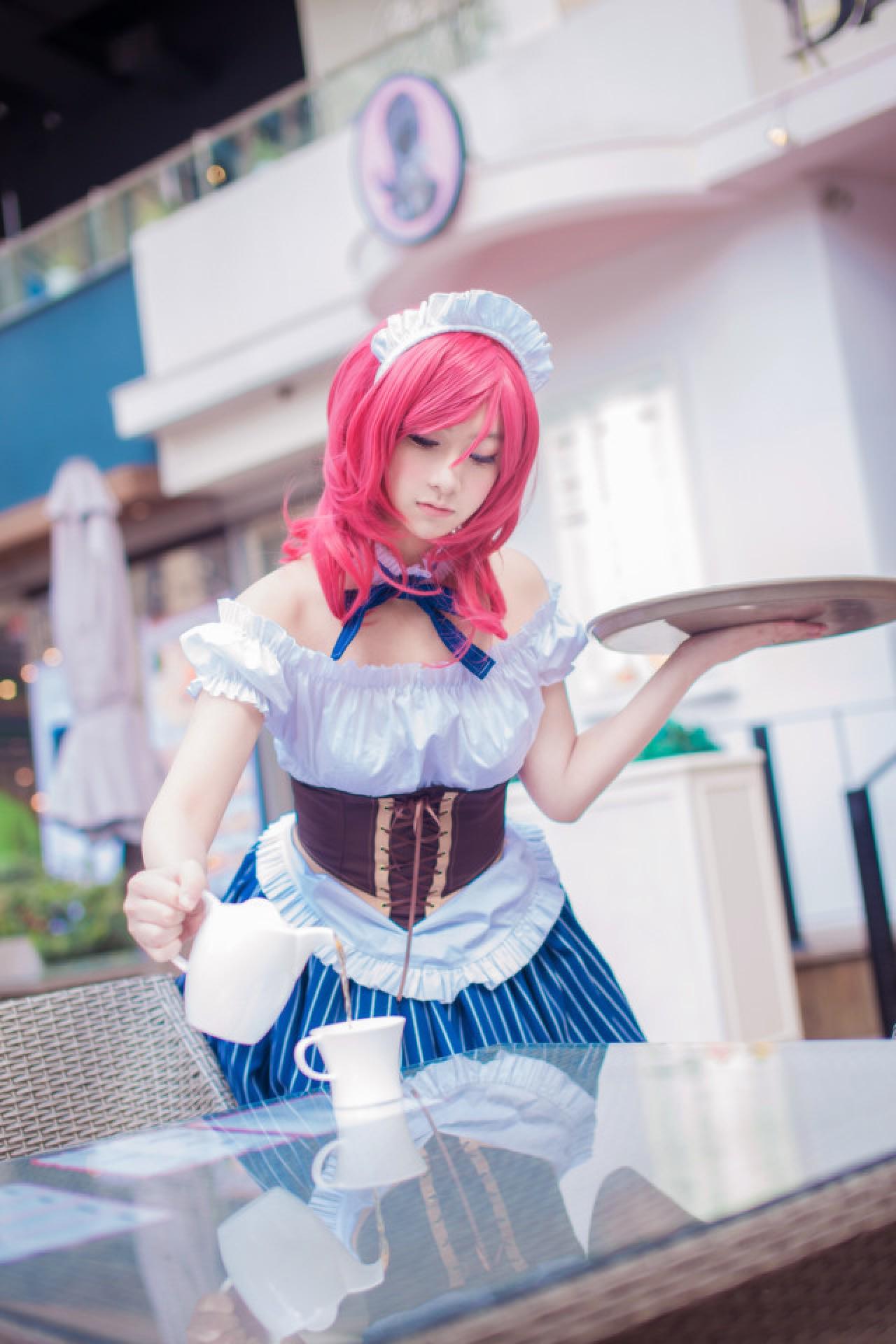 小珞兒扮西木野真姬弯着腰，左手端着盘子，右手握着壶把倒水