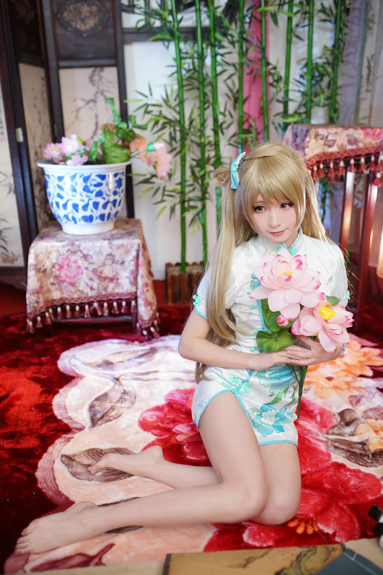 Meter扮南小鸟双手捧着荷花花束坐在红色的地毯上