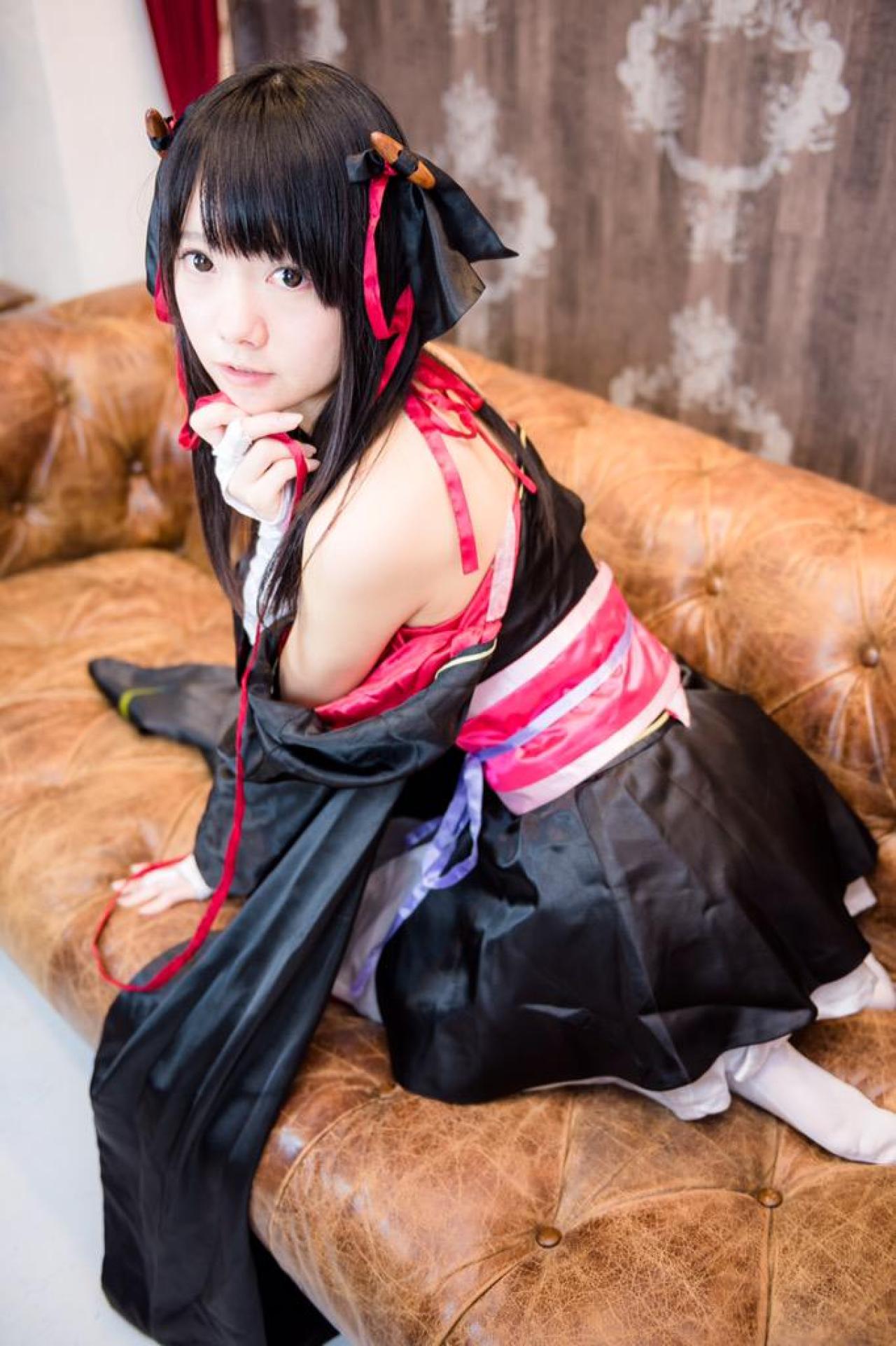 あっきん扮夜夜跪坐在沙发，左手撑在沙发上，右手轻扶下巴