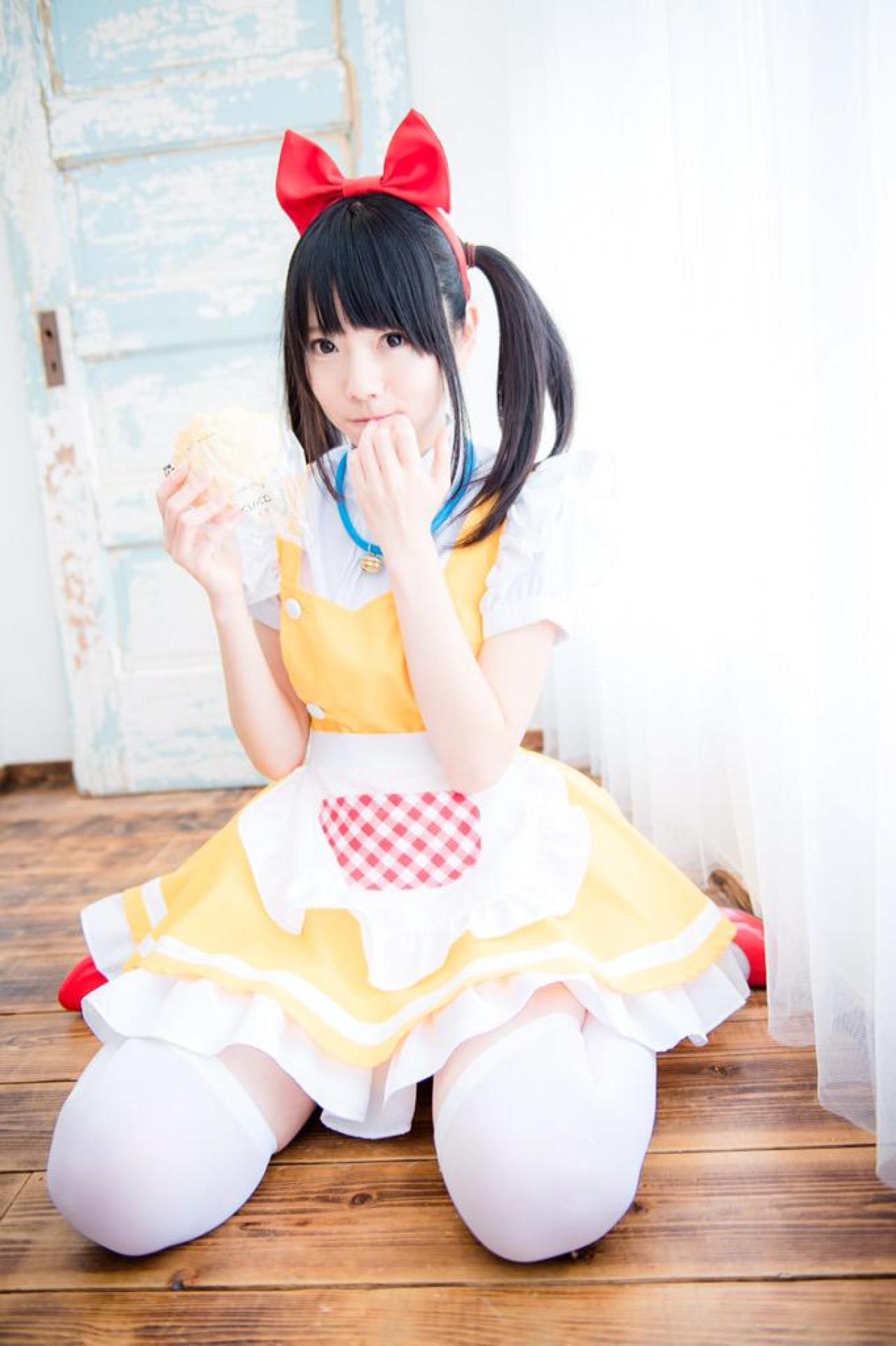 あっきん右手拿着面包，左手轻扶唇角