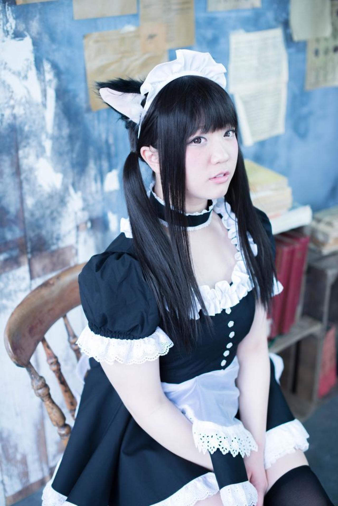 やんころ坐在书架旁的木椅上 3/4侧面