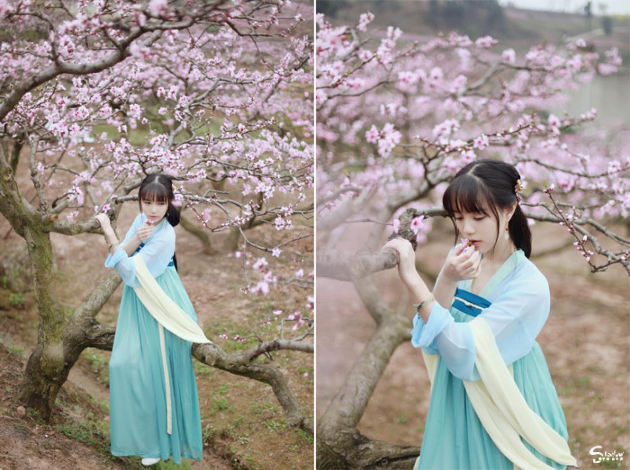 七七左手扶着枝干，右手捏着桃花，坐在树干上