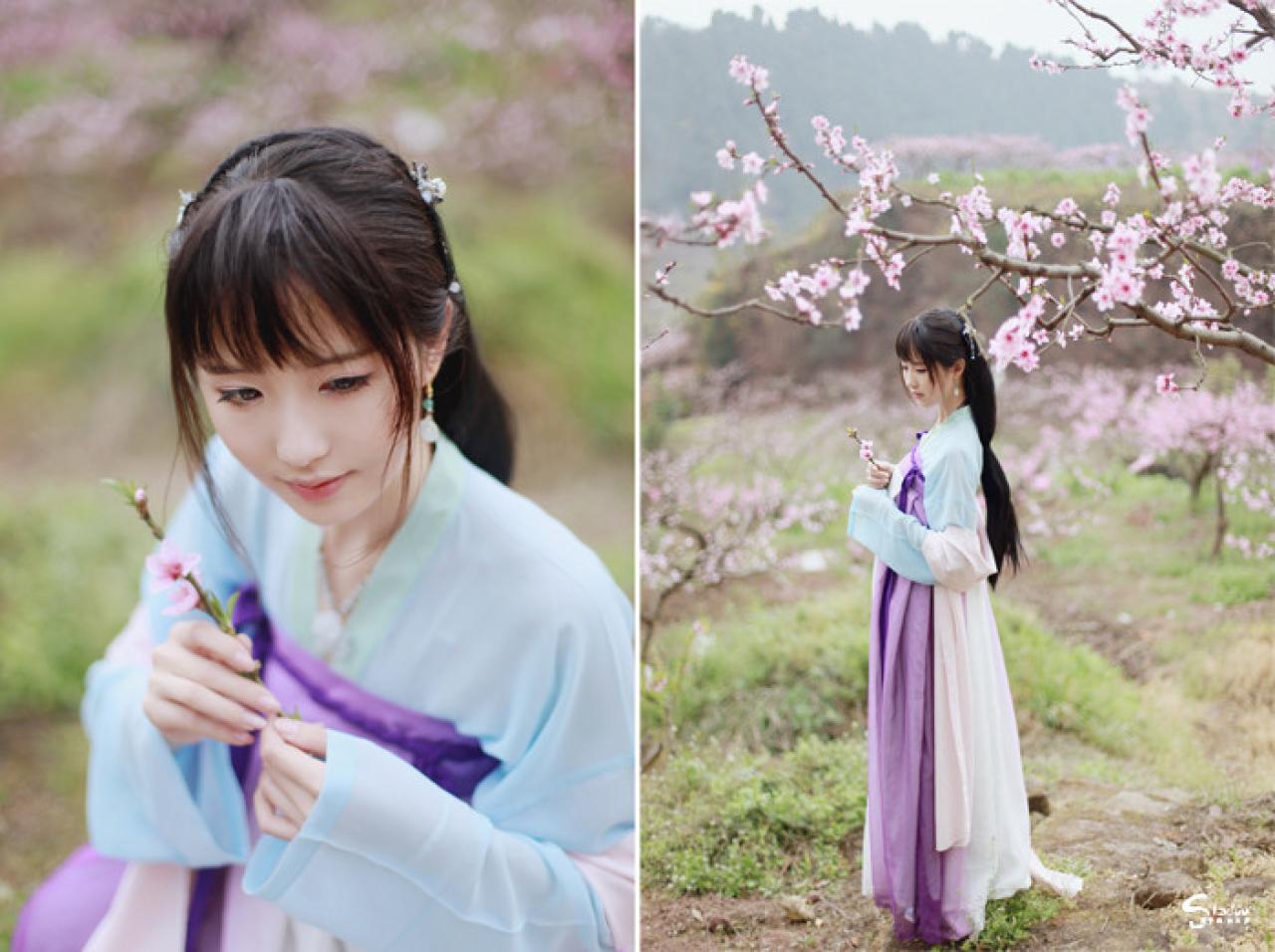 在桃花树下，加加代捏着桃花枝条