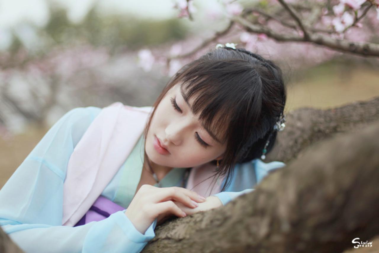 加加代叠放双手扒在在桃花树干上