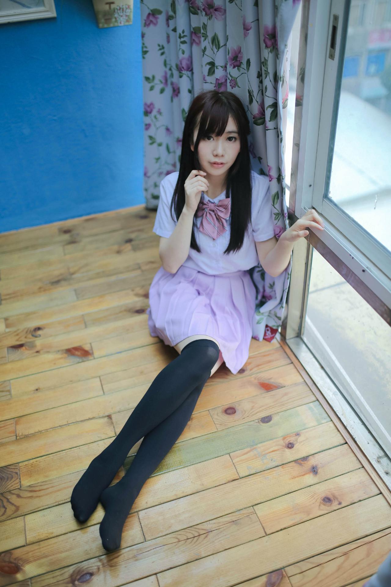 早喵王筱月坐在窗前，左手搭在窗框上，抬起右臂