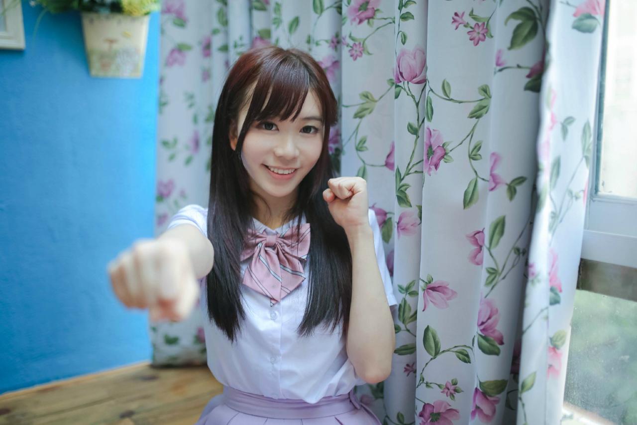 早喵王筱月坐在窗边，半弯左臂，伸出右臂，指着镜头 上半身