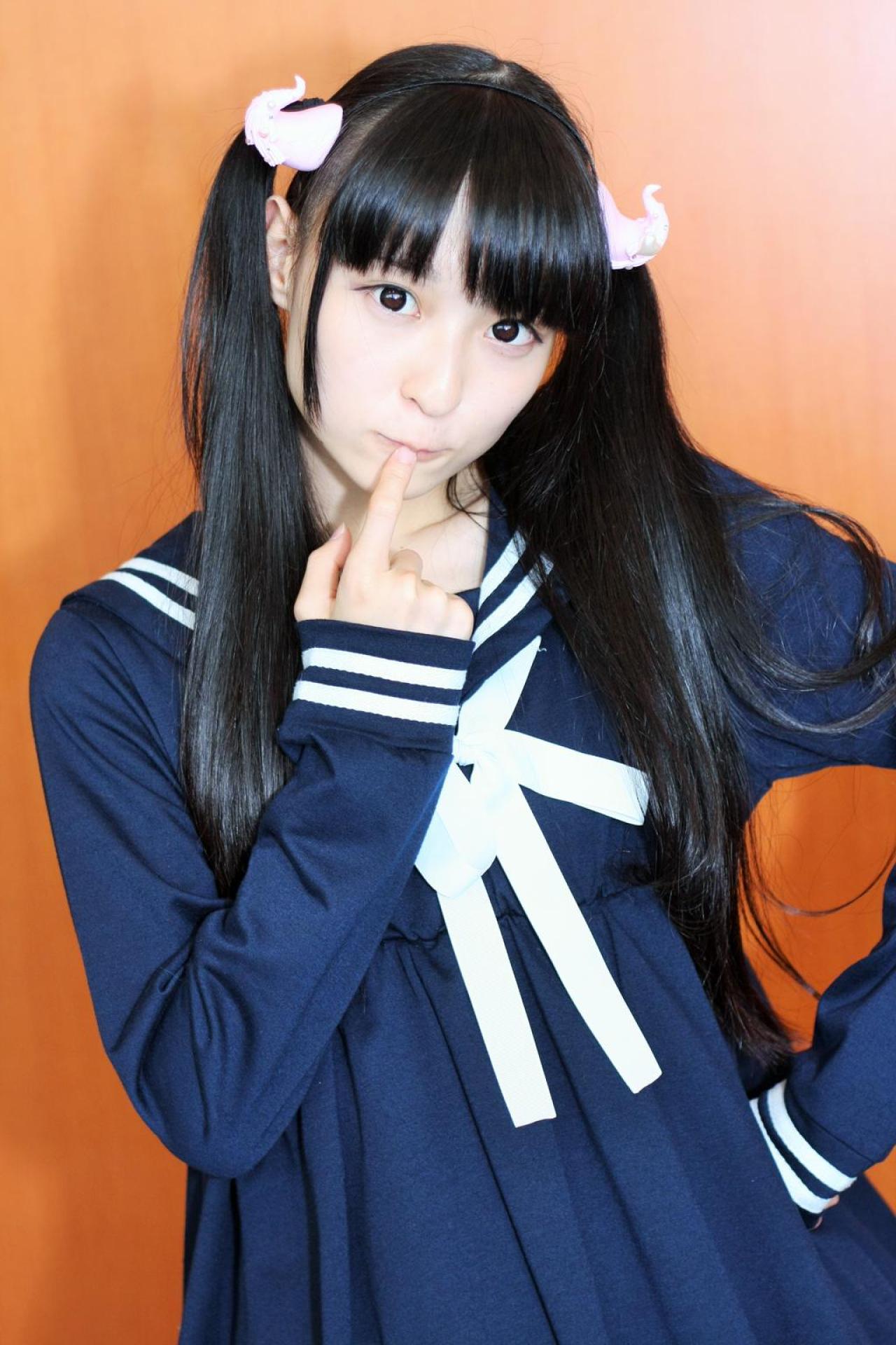 猫守ざーにゃ左手叉腰，右手伸出食指抵着唇角，右侧倾身子的站姿