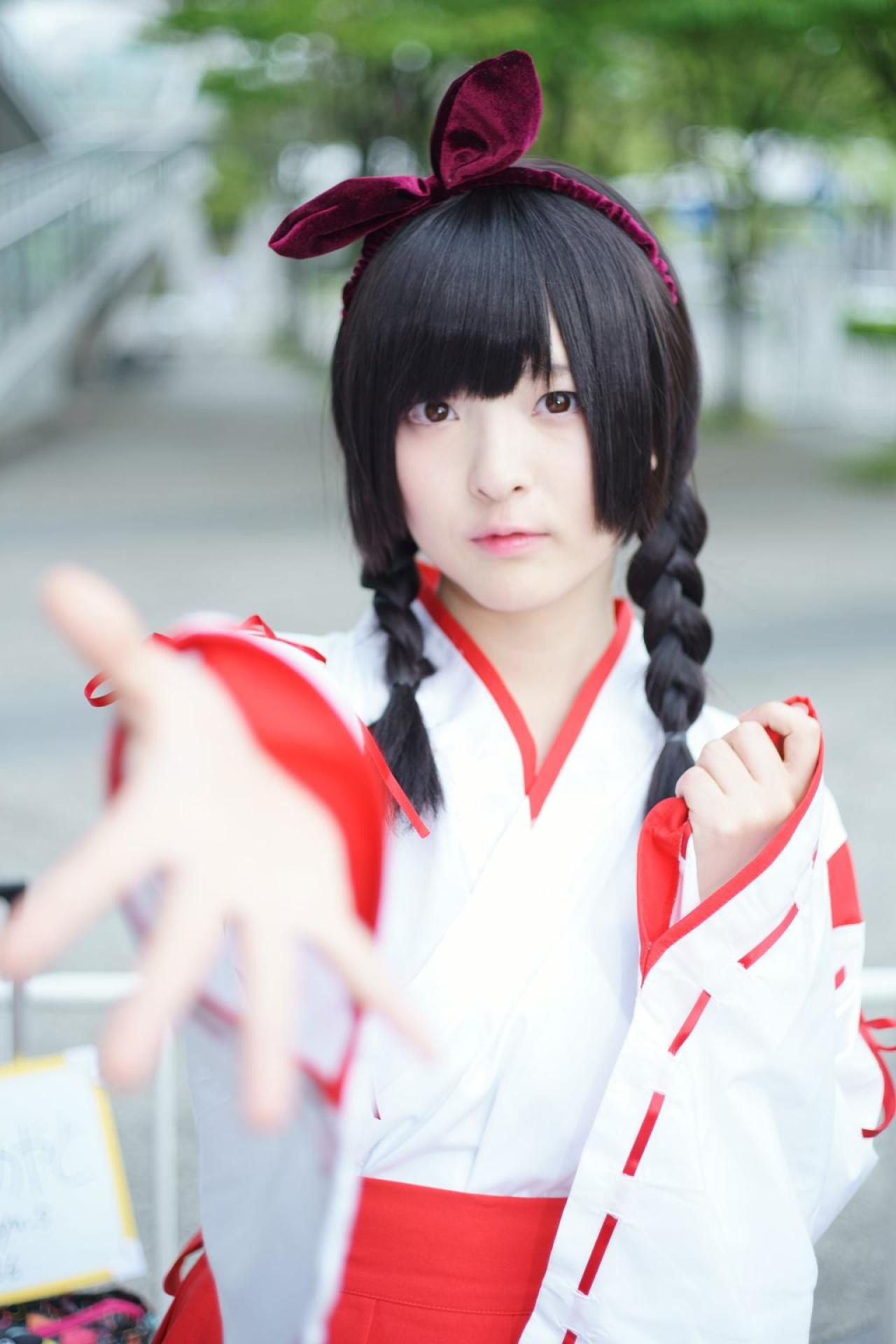 肉球あやと站在栏杆前，半弯左臂，伸出右臂，五指张开