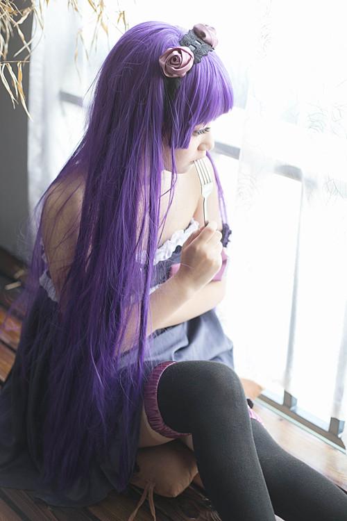 萌妹扮五更琉璃黑猫右手捏着叉子放进嘴里，侧身坐在窗前 3/4侧面