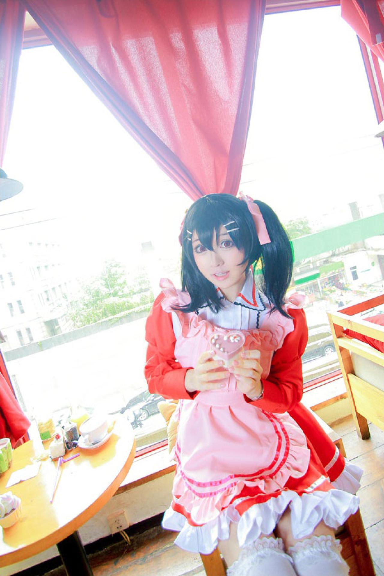 溢灯灯扮矢泽妮可双手捧着心形糖果盒坐在窗前的凳子上