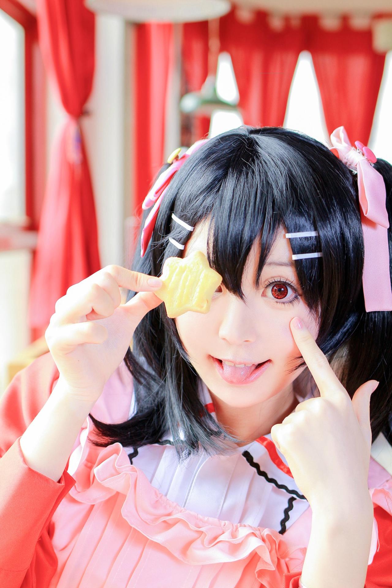 溢灯灯扮矢泽妮可右手捏着六角形饼干，左手食指戳脸，吐舌头卖萌