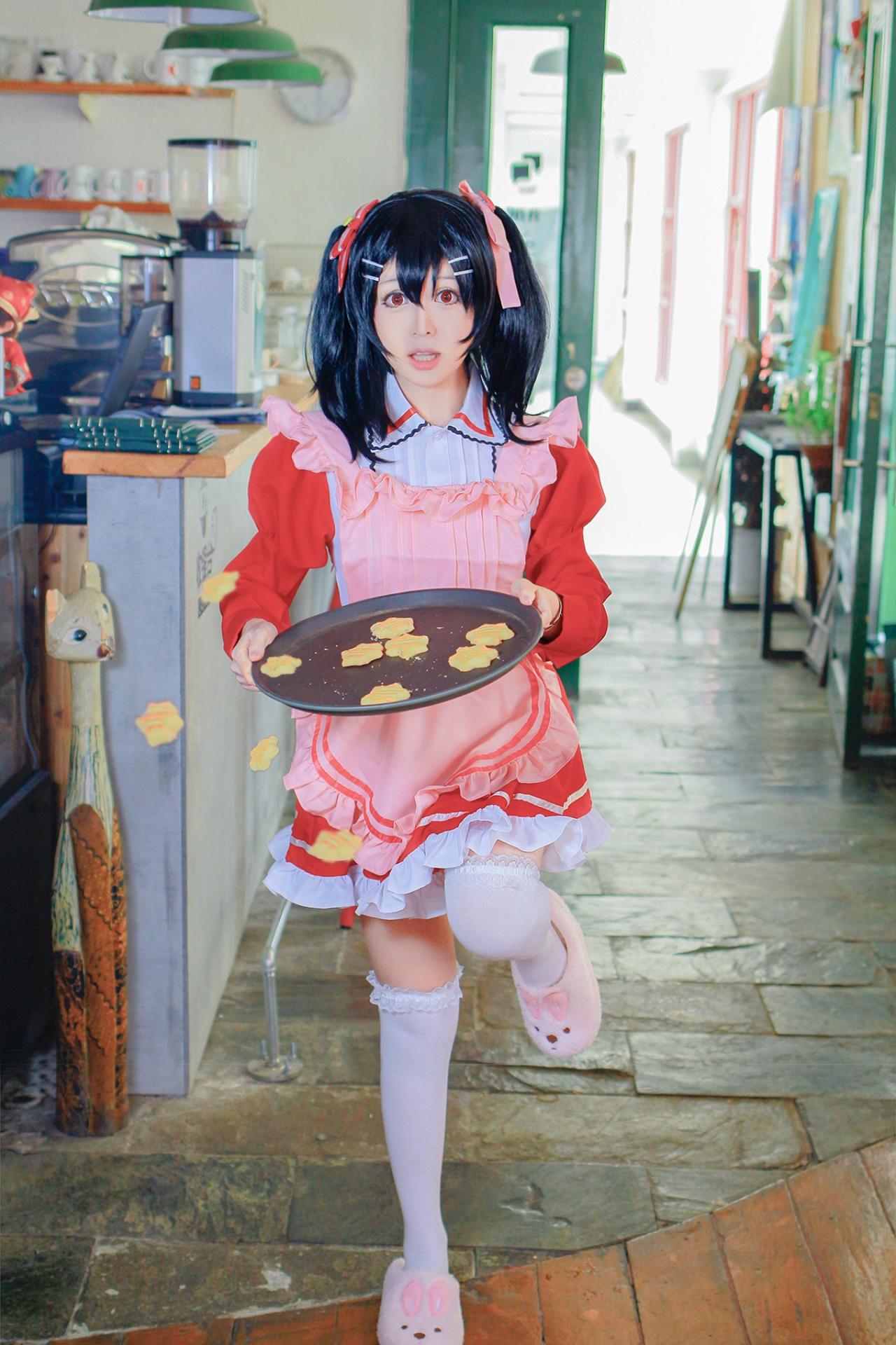 溢灯灯扮矢泽妮可双手端着撑着饼干的盘子，抬起左腿，快要跌倒弄洒饼干的站姿