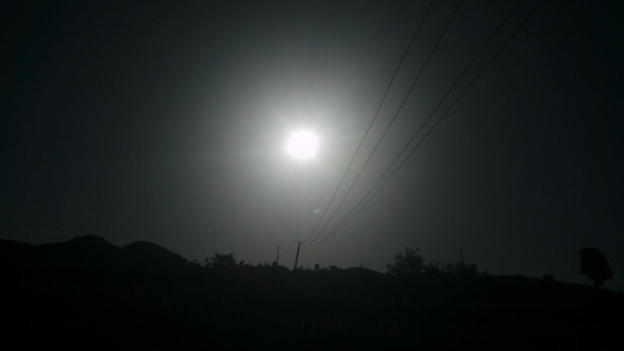 逆光下的太阳和向上穿过余晖的电线杆