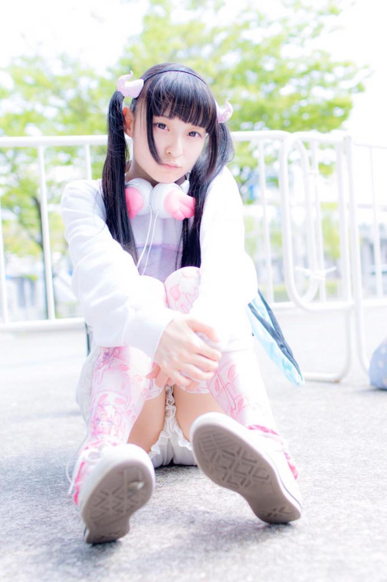 猫守ざーにゃ双手怀抱双腿，坐在栏杆前，左歪头：看什么呢？