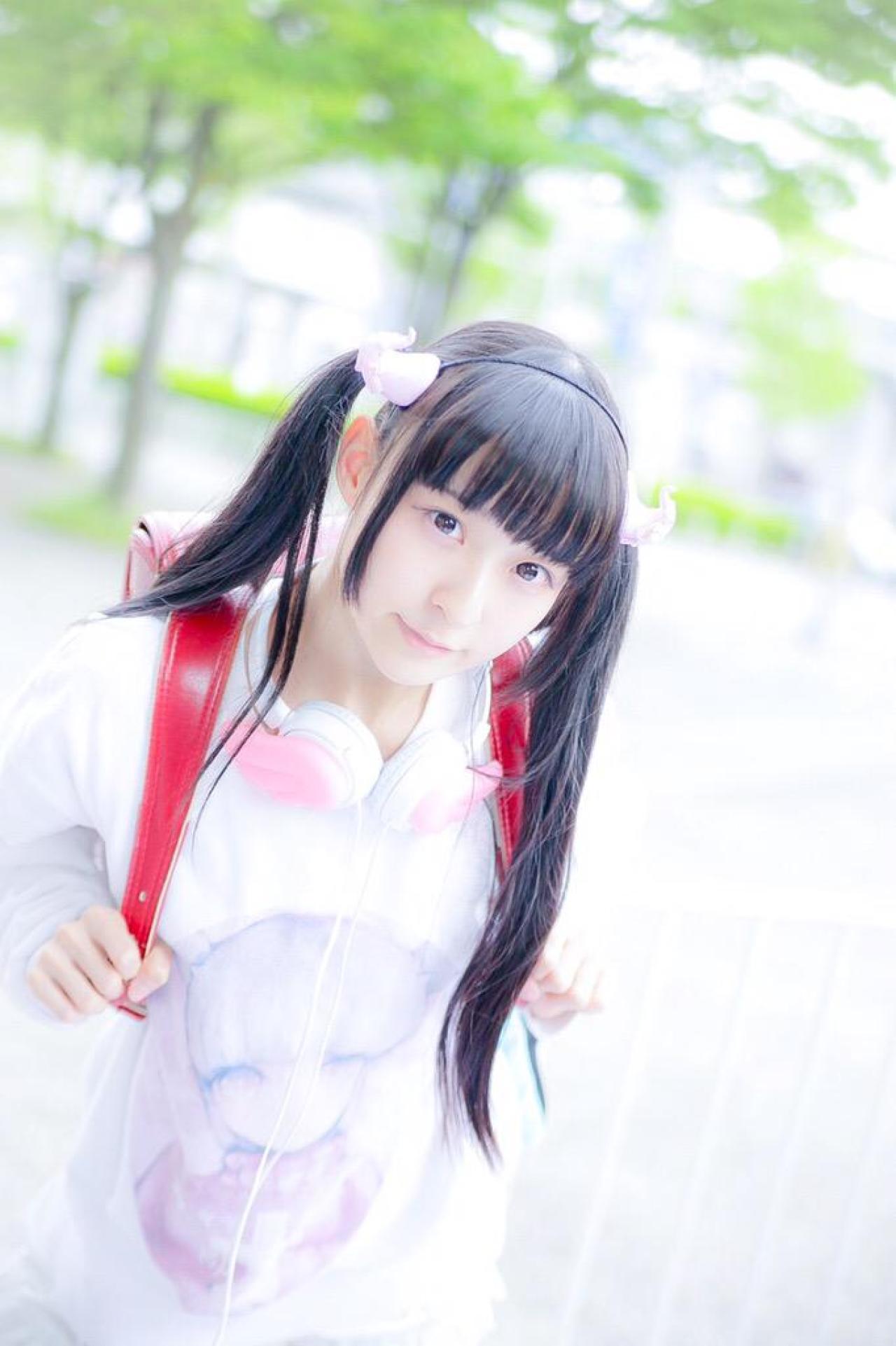 猫守ざーにゃ双手握着双肩包的肩带，站在栏杆前