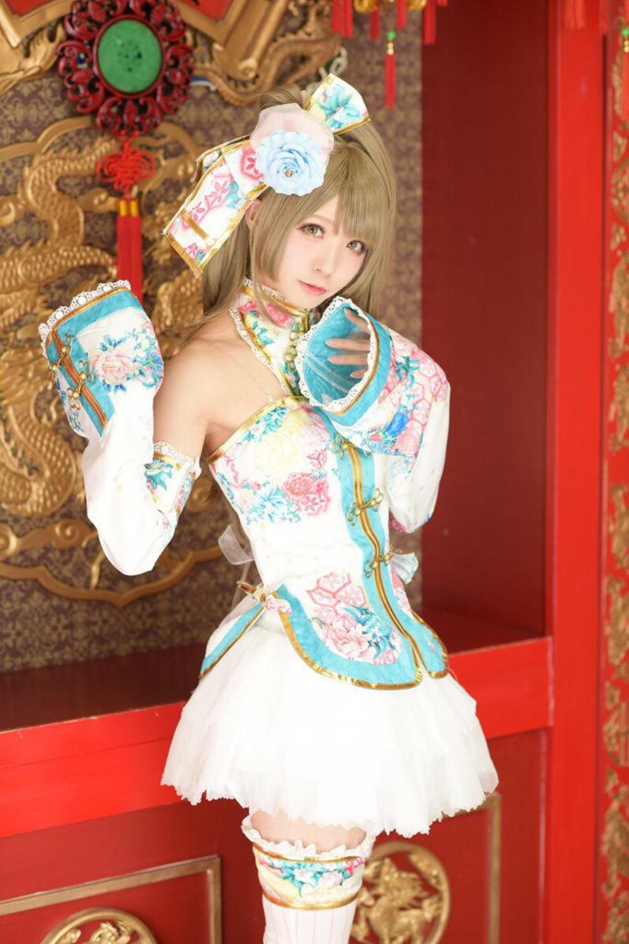 茉夏扮南小鸟站在龙图案的红墙前