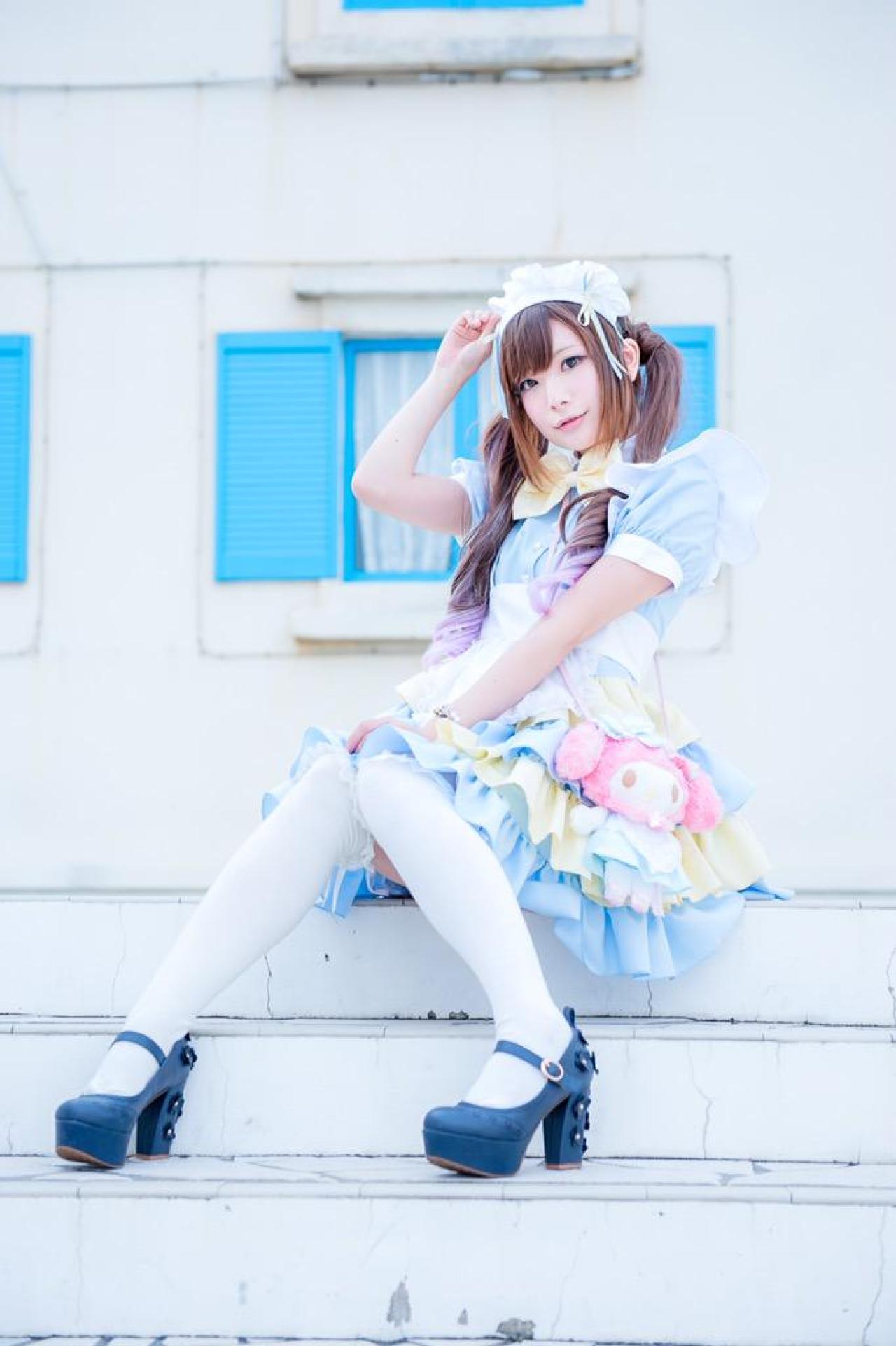 神坂琉菜坐在台阶上，左手搭在膝盖上，右手扶着发饰 3/4侧面