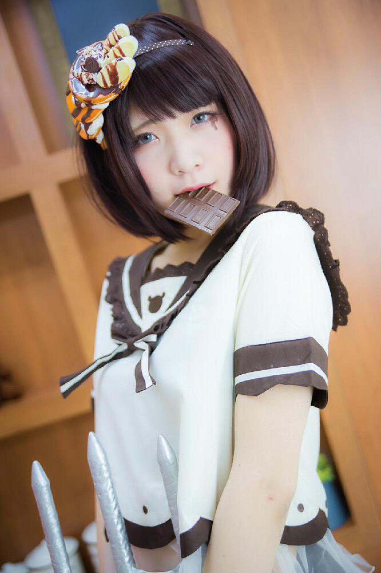 唄汰音おれぱ扮巧克力娘叼着方块巧克力站在展示柜前 上半身 3/4侧面