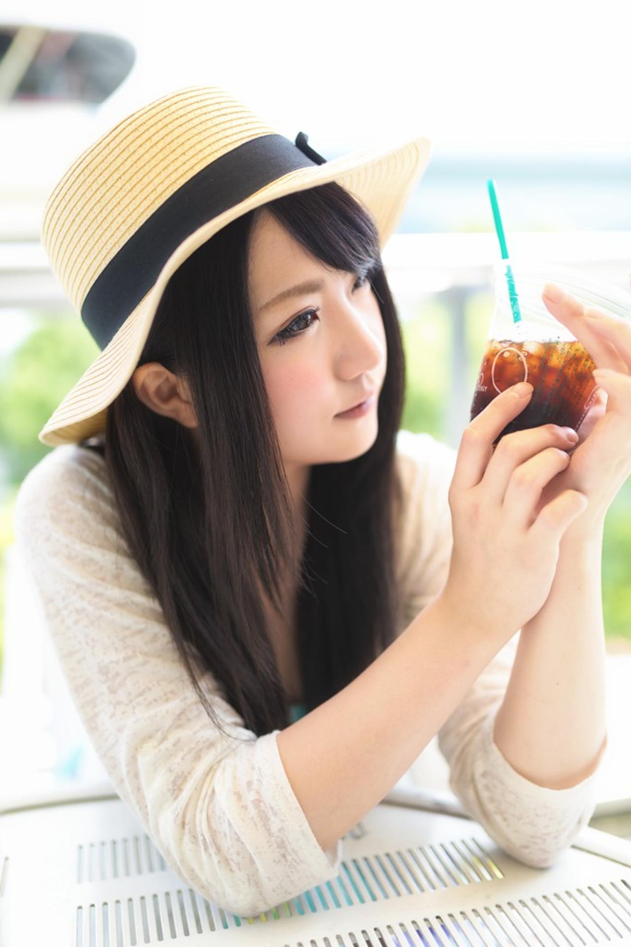 らぎ坐在休闲椅上，双手捧着饮料杯，端详的侧脸