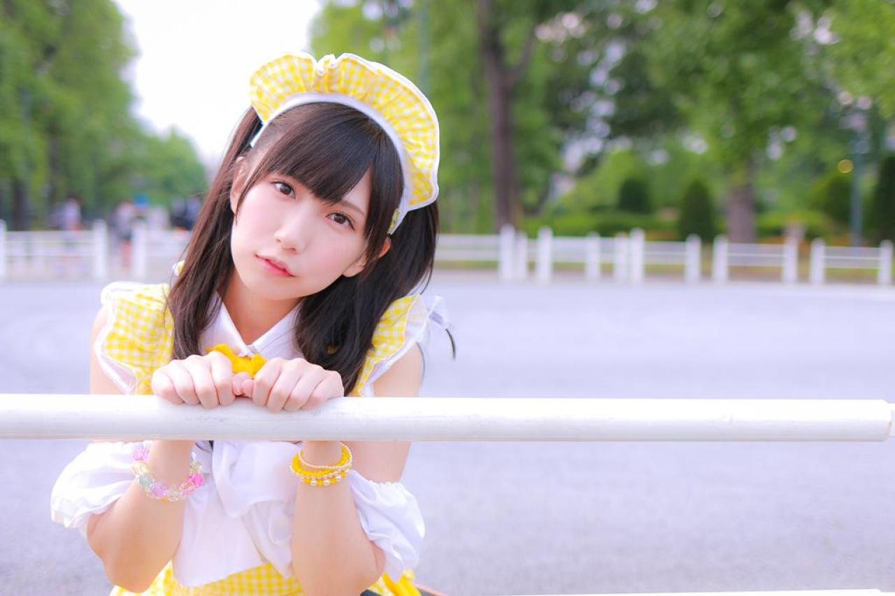 小日向くるみ扮女仆，双手半握拳作猫爪状，扒在白色栏杆上，歪着头