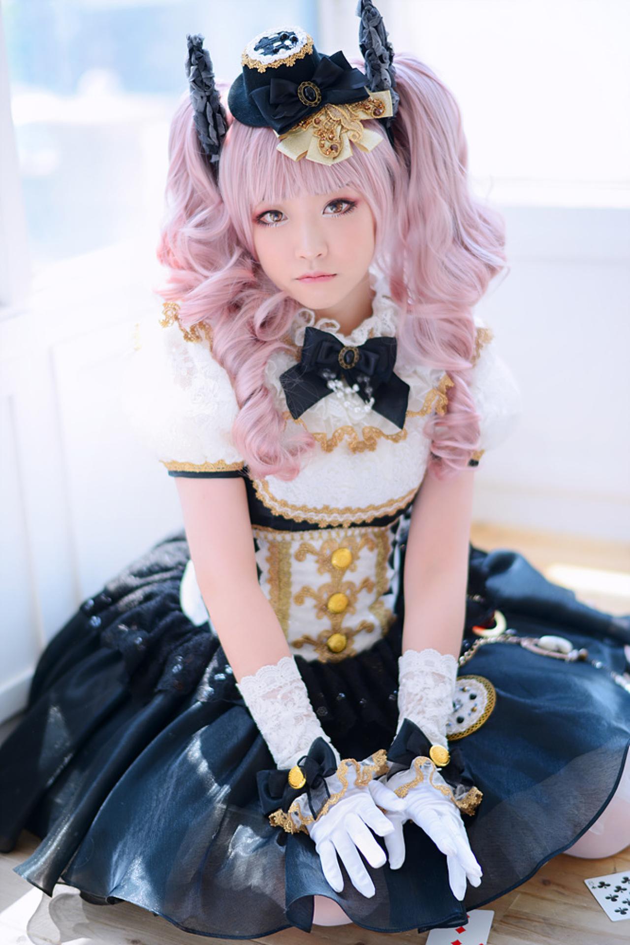 兔娘tomia扮爱丽丝跪在窗前，双手搭在裙摆上，裙摆周围散落着扑克牌