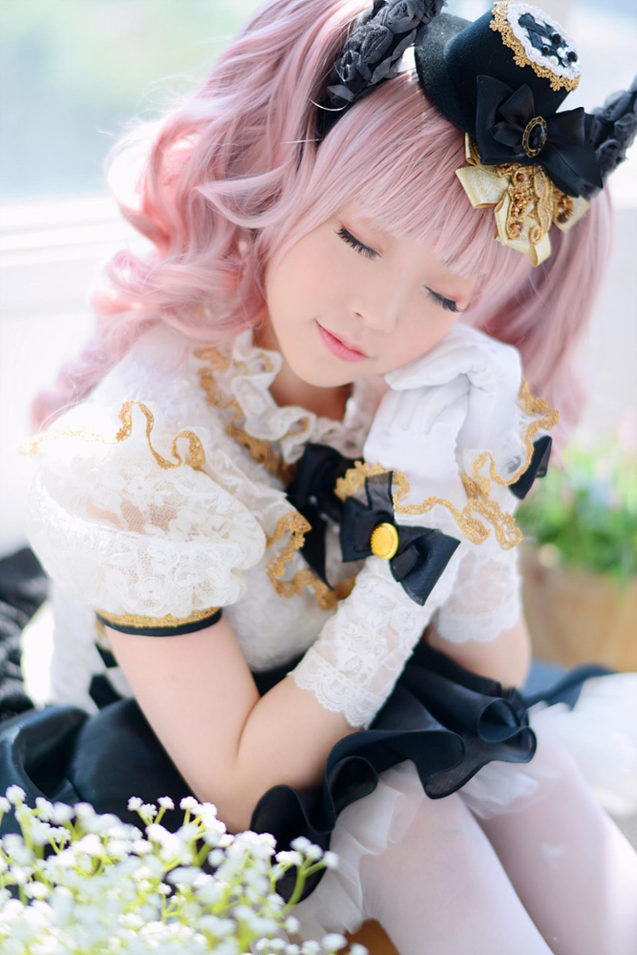 兔娘tomia扮爱丽丝脸颊贴着双手，坐在花后