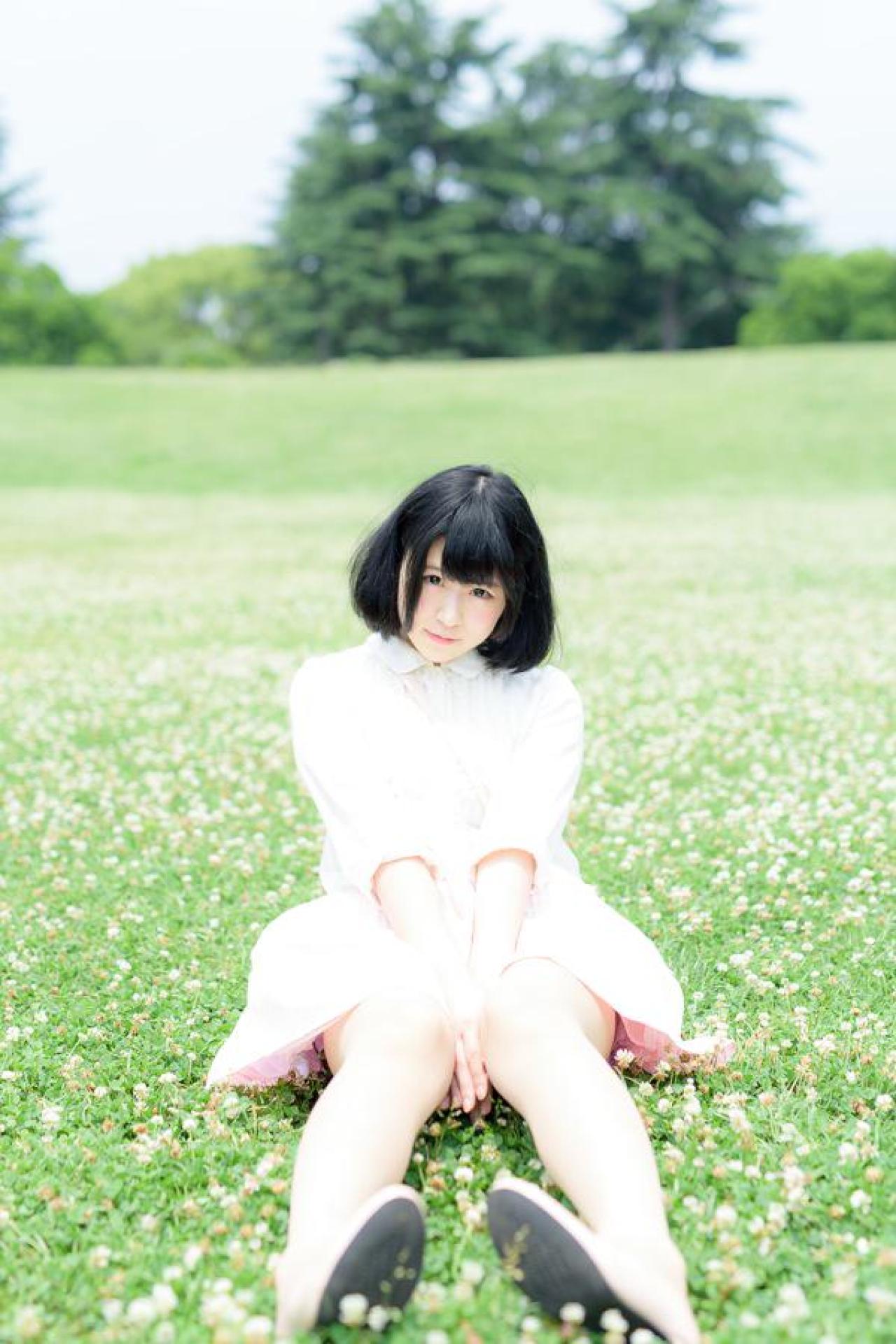 モニ子坐在草地，双手叠放在裙摆上 正面
