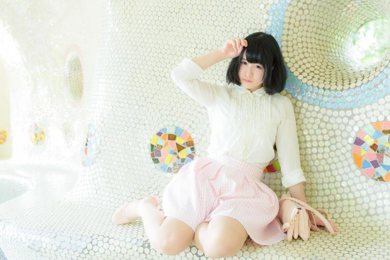 モニ子右手轻抚刘海儿，左手撑着椅面 坐姿