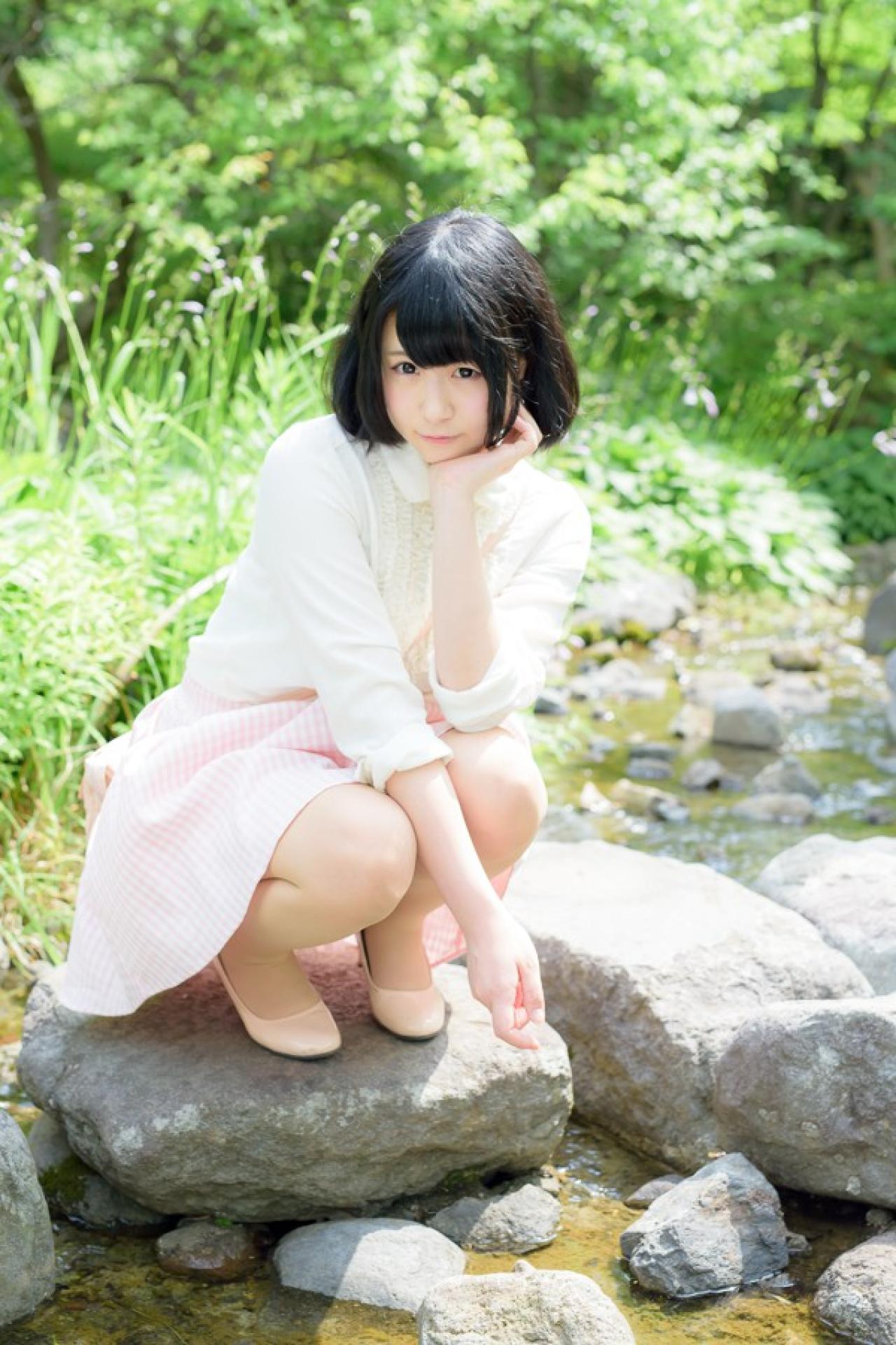 モニ子蹲在溪水边的石级上，左手撑着下巴