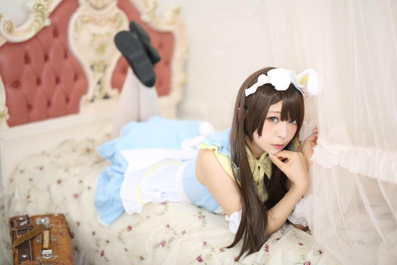 かりちゃ翘着腿，扒在床上，右手撑着下巴，左手轻扶帘子