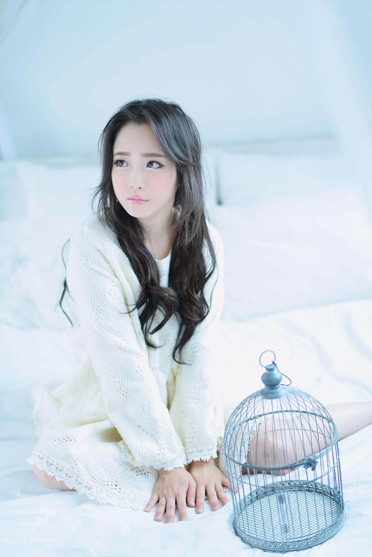 兔娘坐在床上，身前放着一个鸟笼
