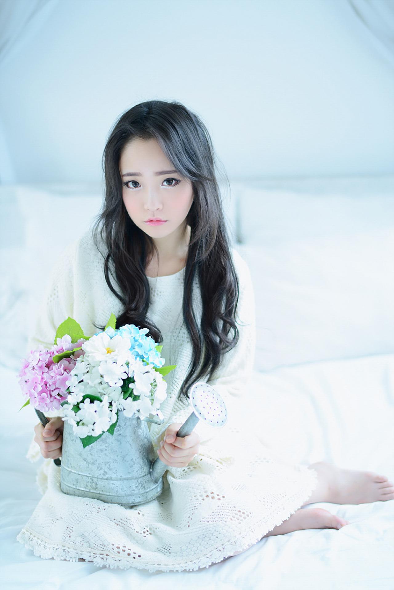 兔娘双手捧着装满鲜花的洒水壶坐在床上