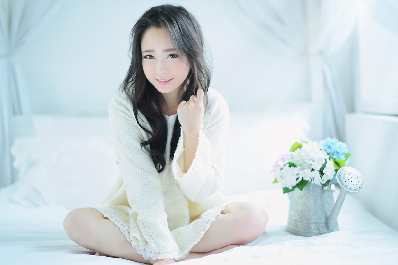 兔娘盘腿坐在床上，身旁放着洒水壶，作“勾引”手势，微笑