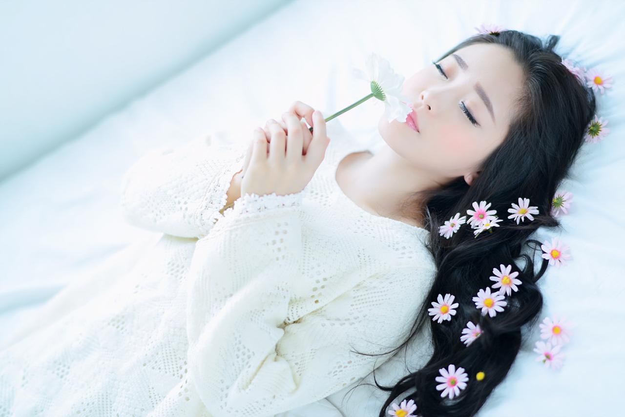 兔娘躺在床上，双手捧着花束，闭眼轻闻香气