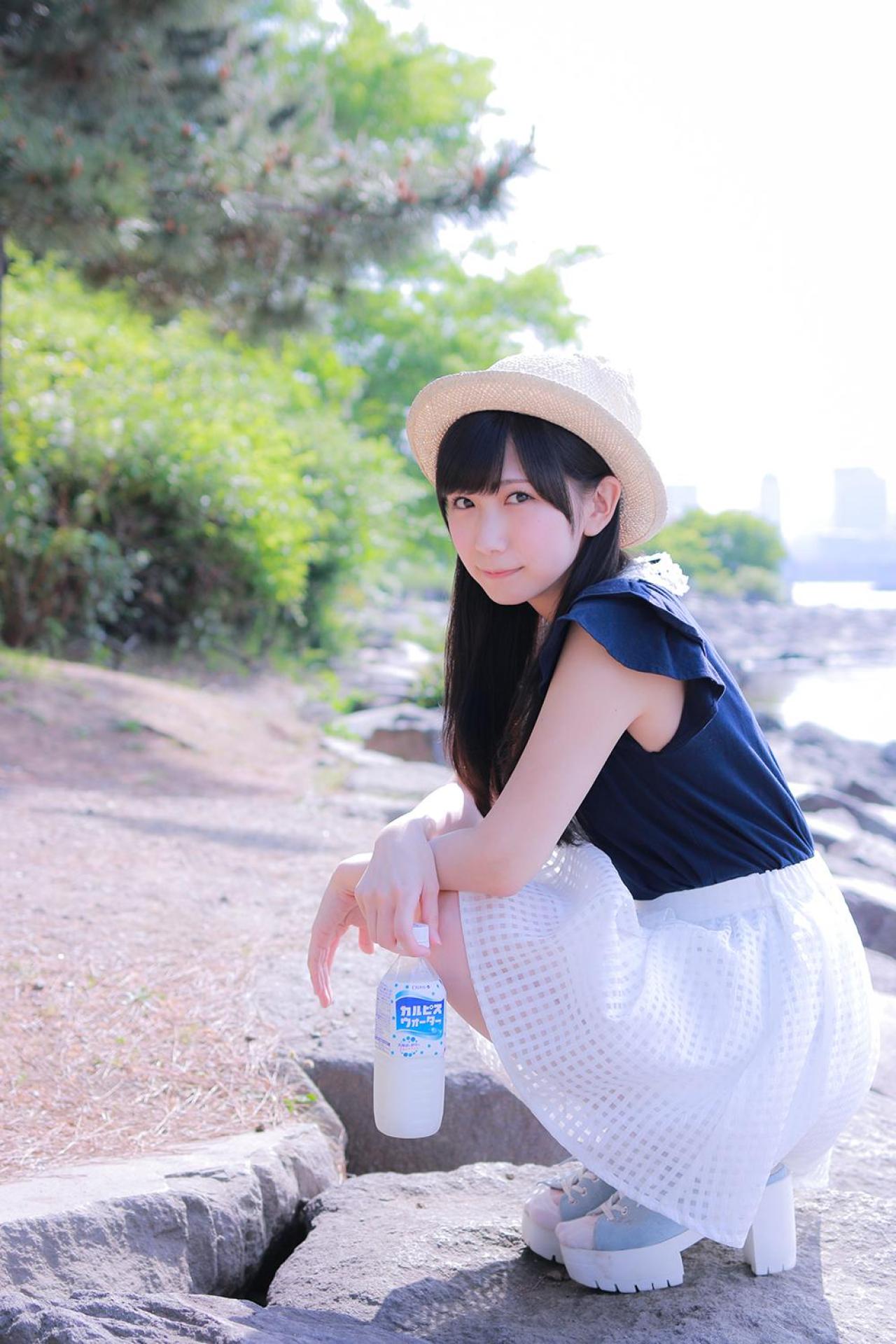 小日向くるみ拎着可尔必思饮料蹲在石级上