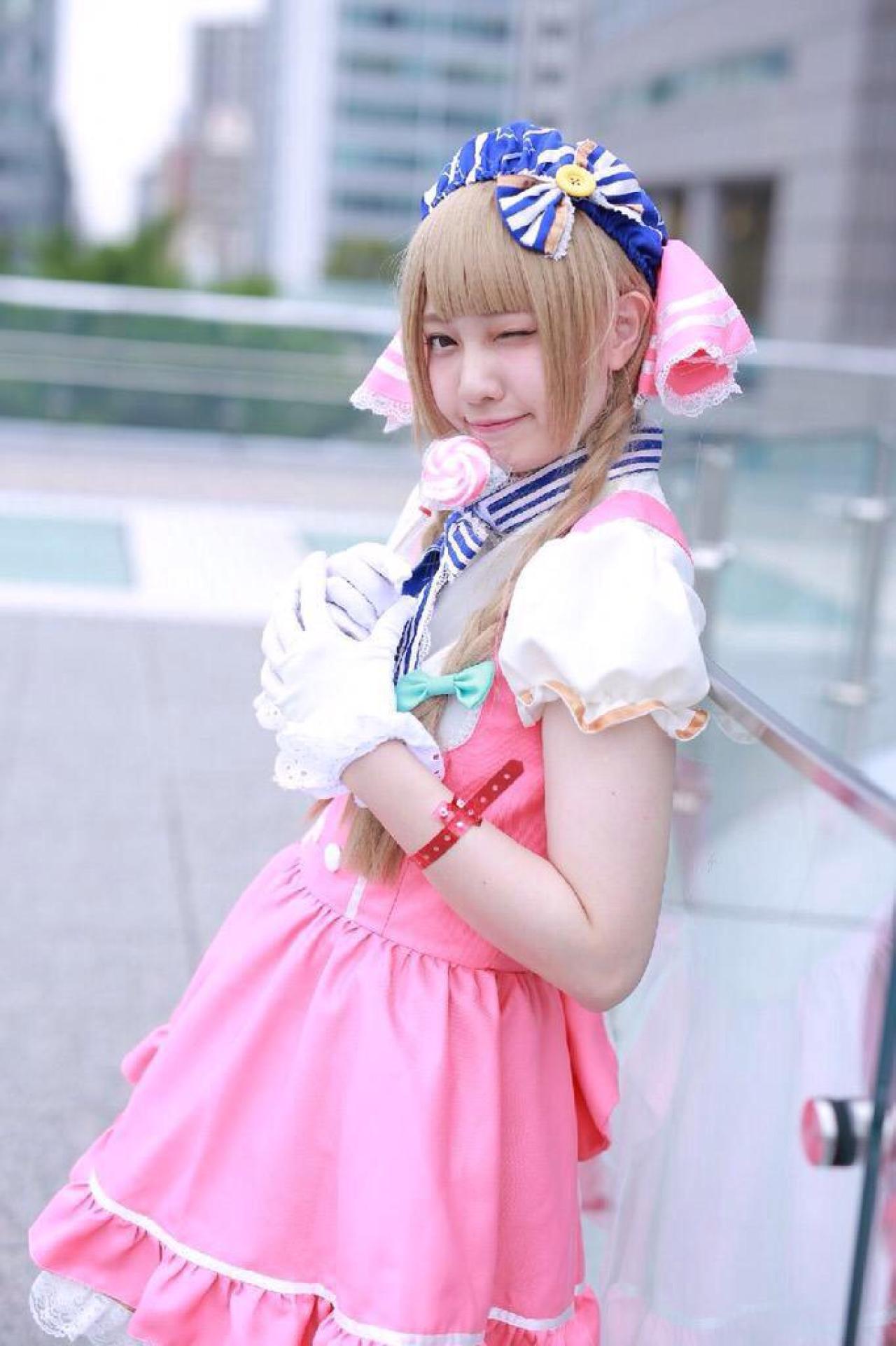 玖音さん扮南小鸟双手捧着棒棒糖，眨眼卖萌，侧面站姿