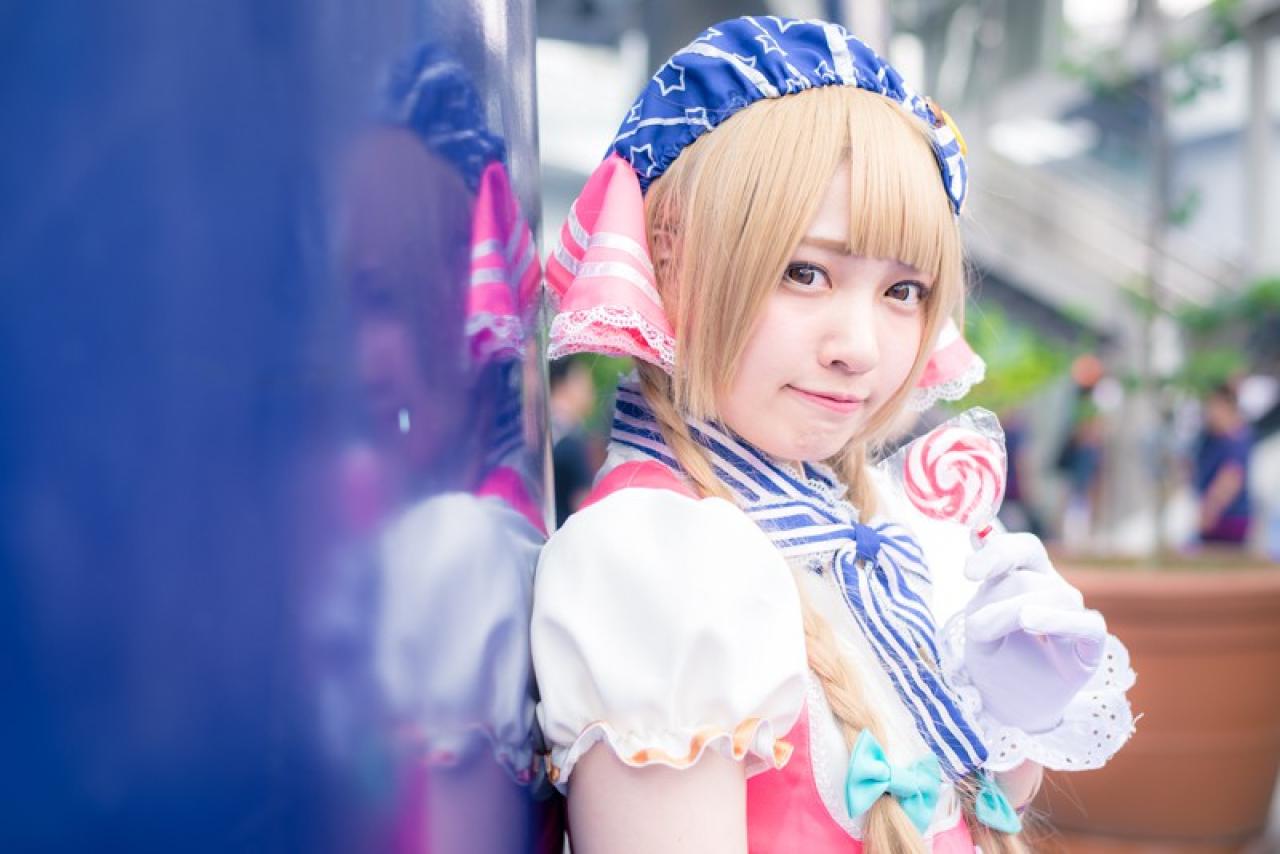 玖音さん扮南小鸟拿着棒棒糖侧身靠在墙面上