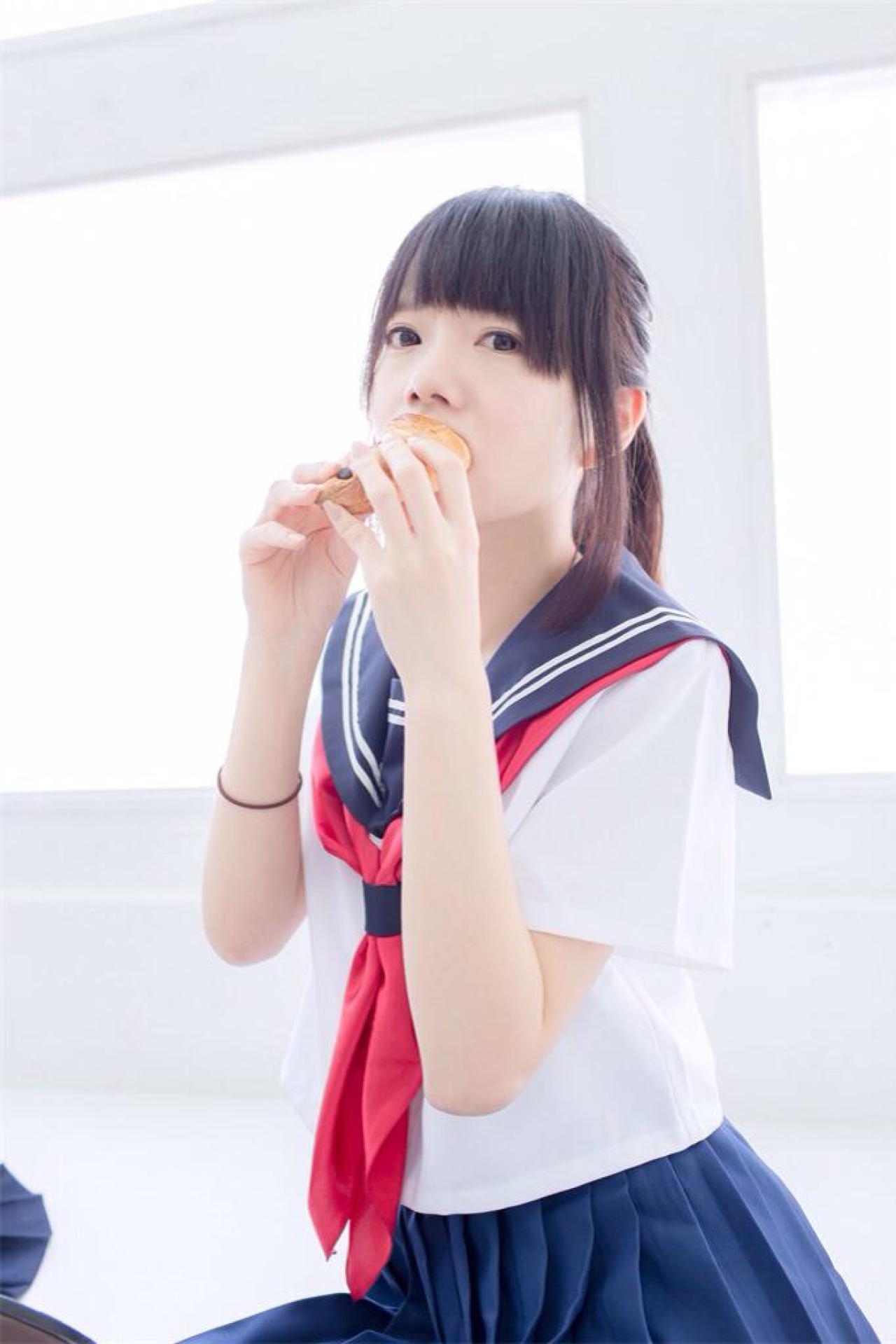 あっきん双手将面包放进嘴里，吃包卖萌