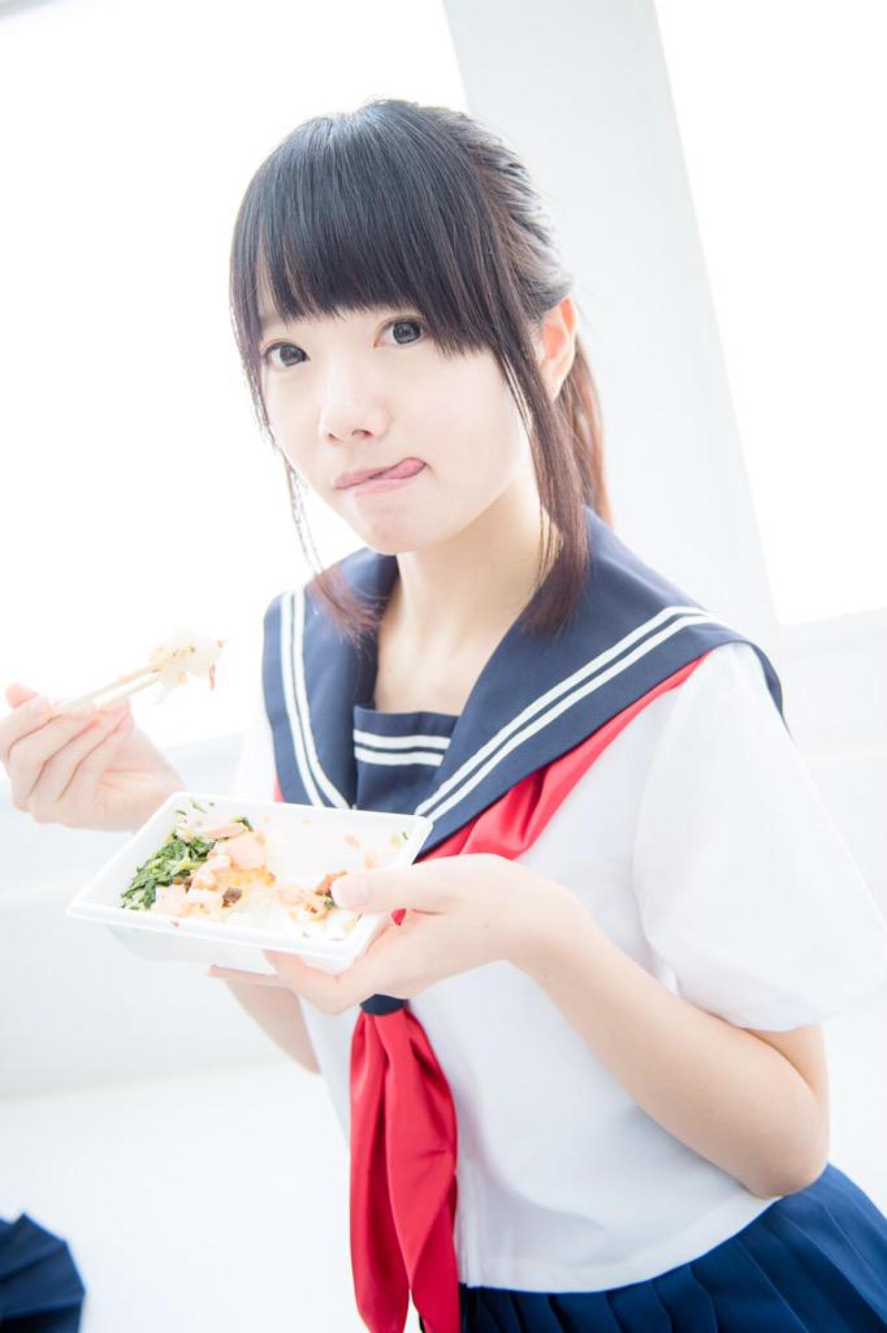 あっきん右手拿着筷子夹食物，左手端着盒饭，吐舌卖萌，看上去很好吃的样子