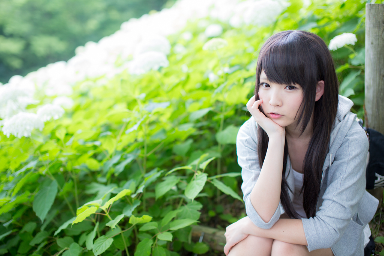 せん坐在白色紫阳花的花丛旁，右手撑脸