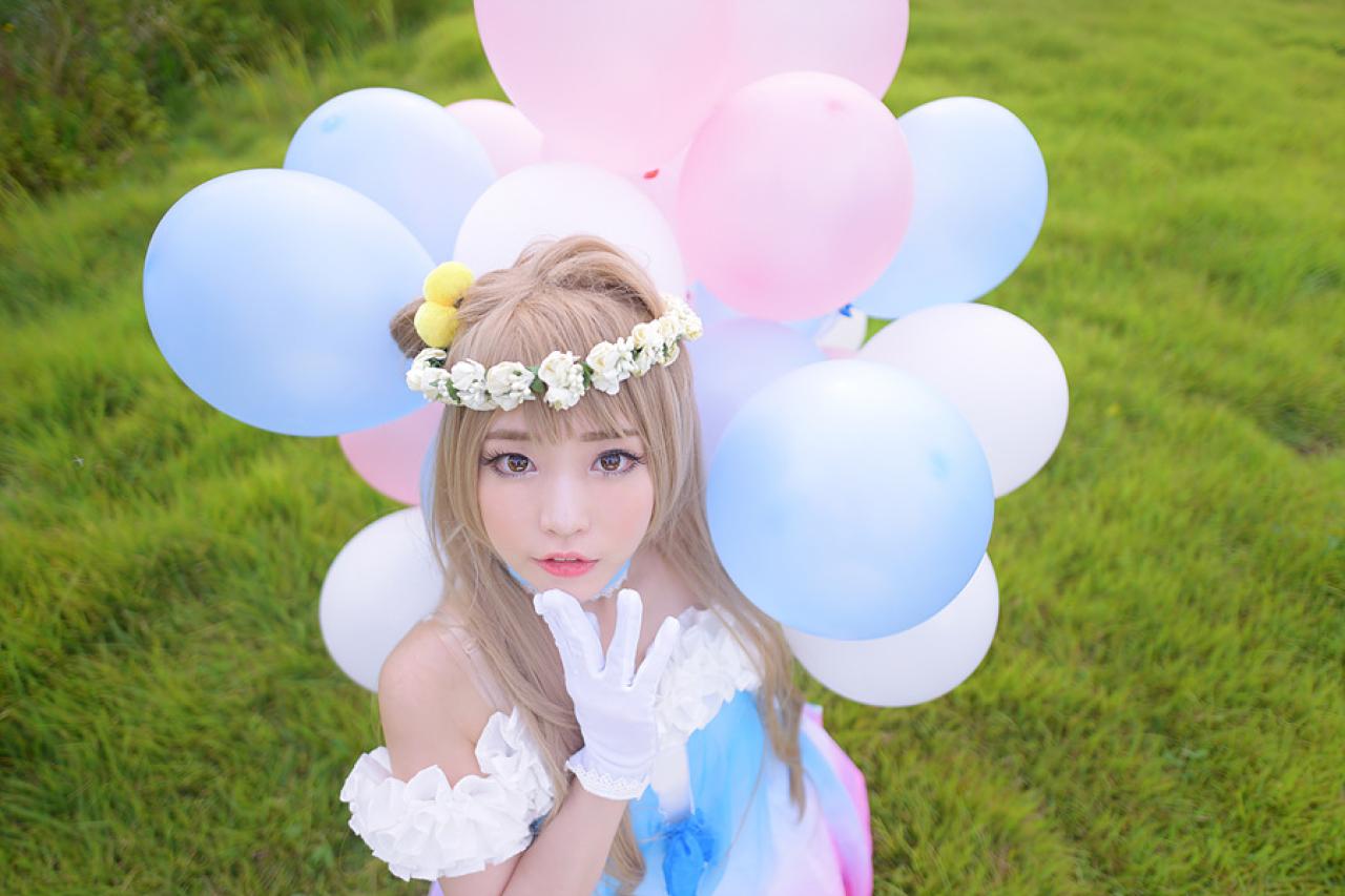 兔娘tomia扮演南小鸟拿着气球，右手手指轻抵下巴