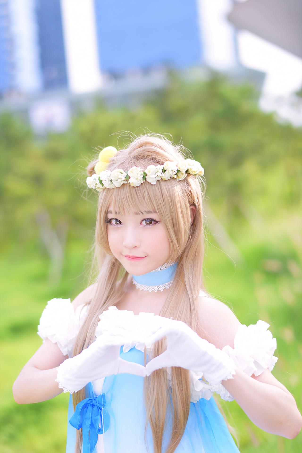 兔娘tomia扮南小鸟站在草地上，双手作心形手势