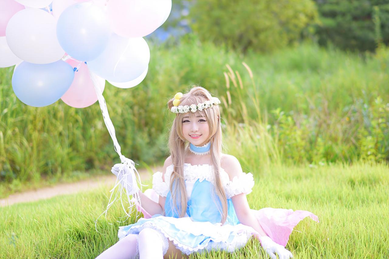 兔娘tomia扮南小鸟右手拿着气球，坐在草地上的正面