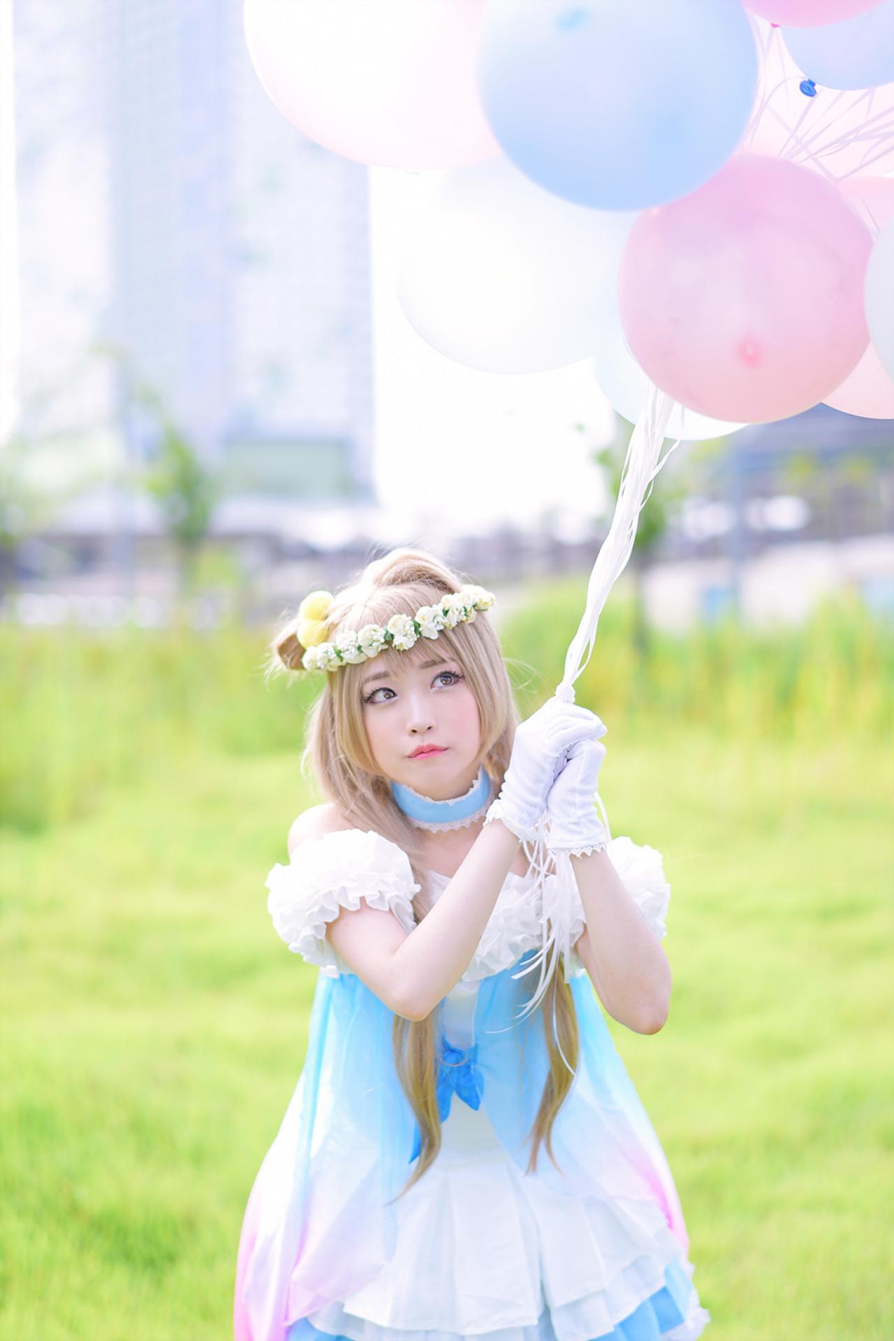 兔娘tomia扮南小鸟双手握着气球，斜视仰望天空，站在草地上