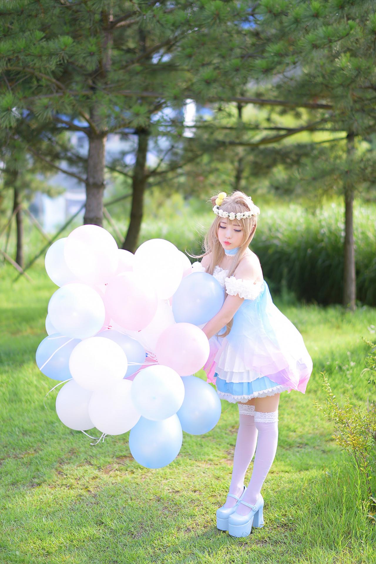 兔娘tomia扮南小鸟双手拿着气球，站在草地上，嘟嘴卖萌 3/4侧面