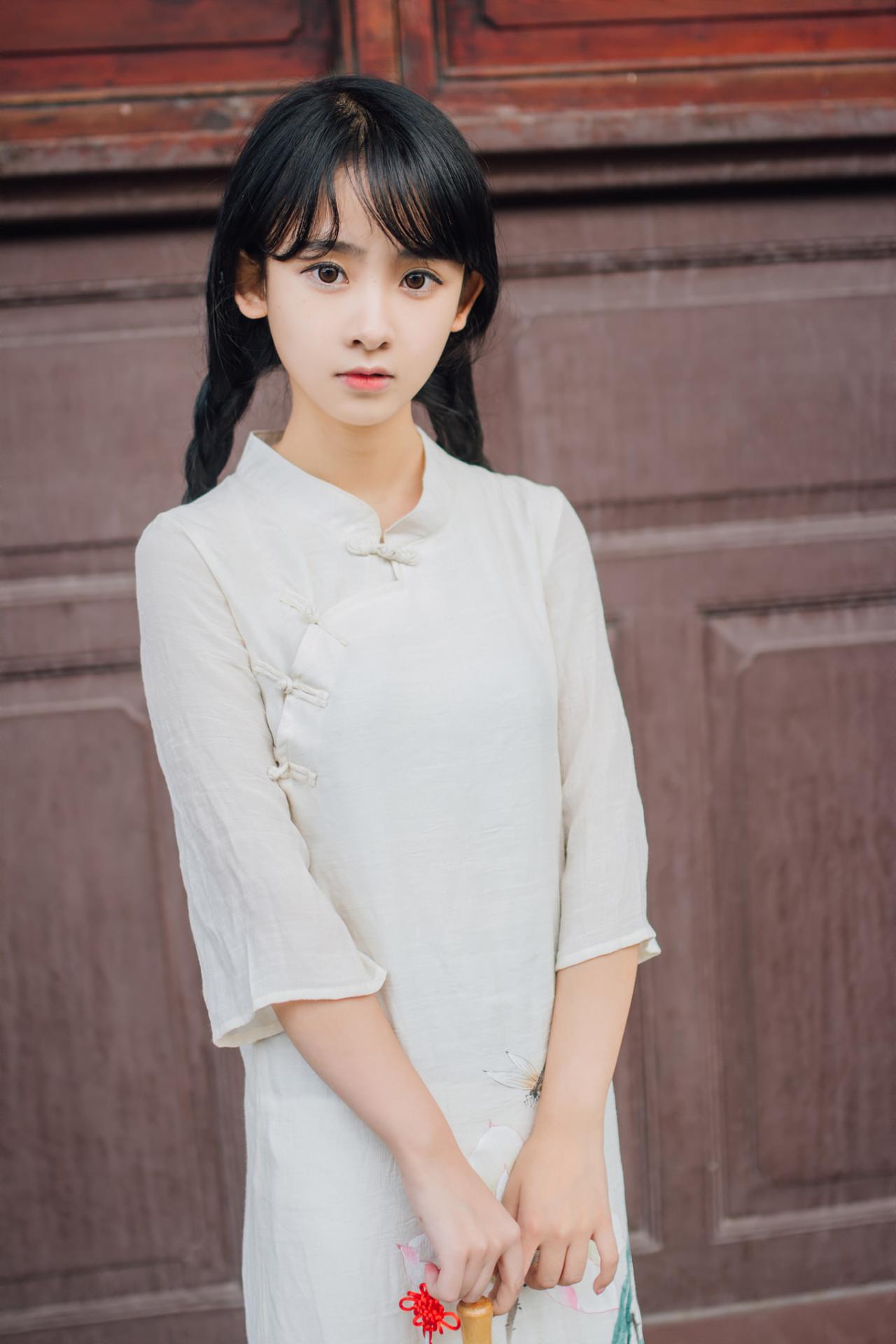 巫京蔓红木门前正面照